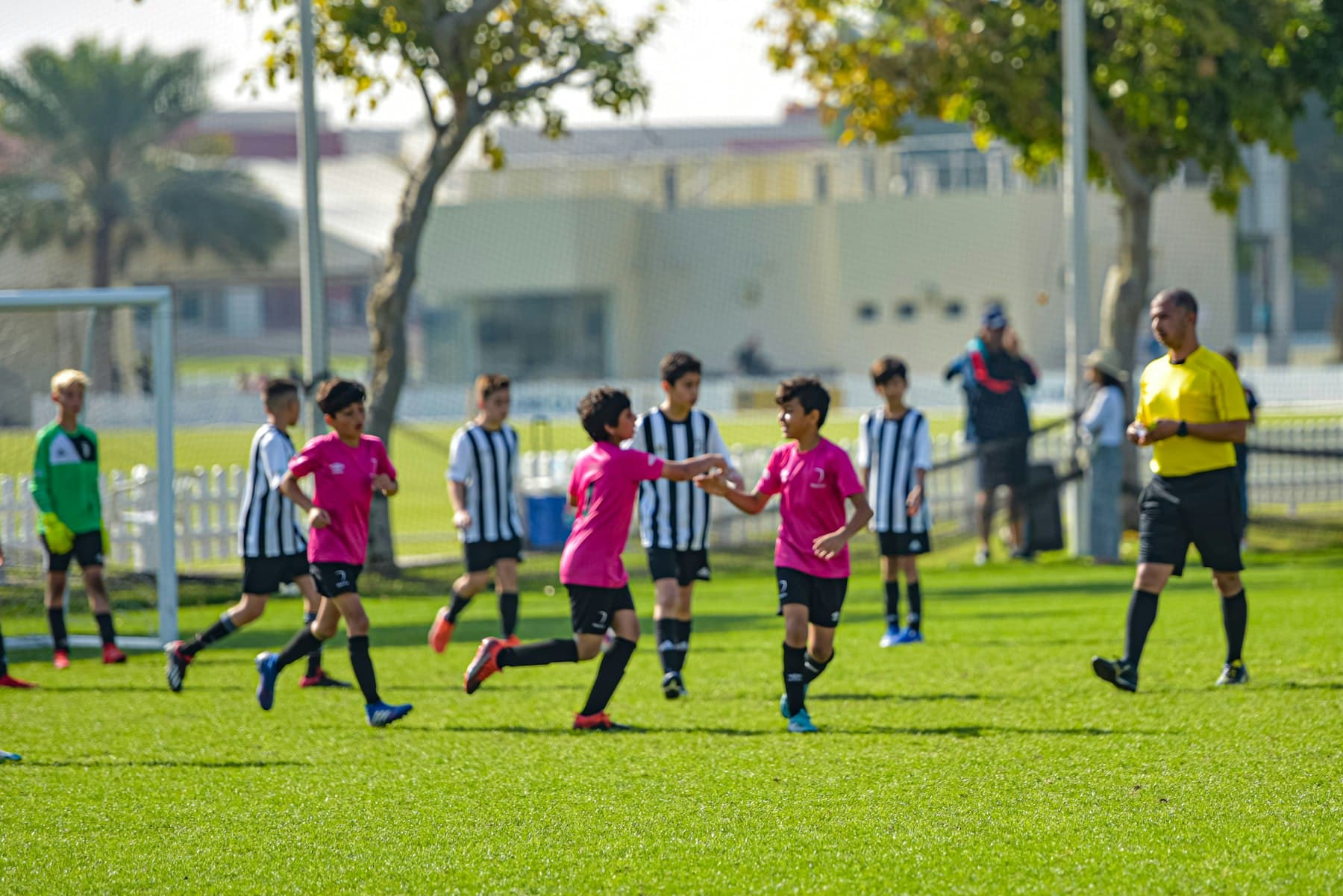 Youth soccer players in custom red and white team uniforms on the field